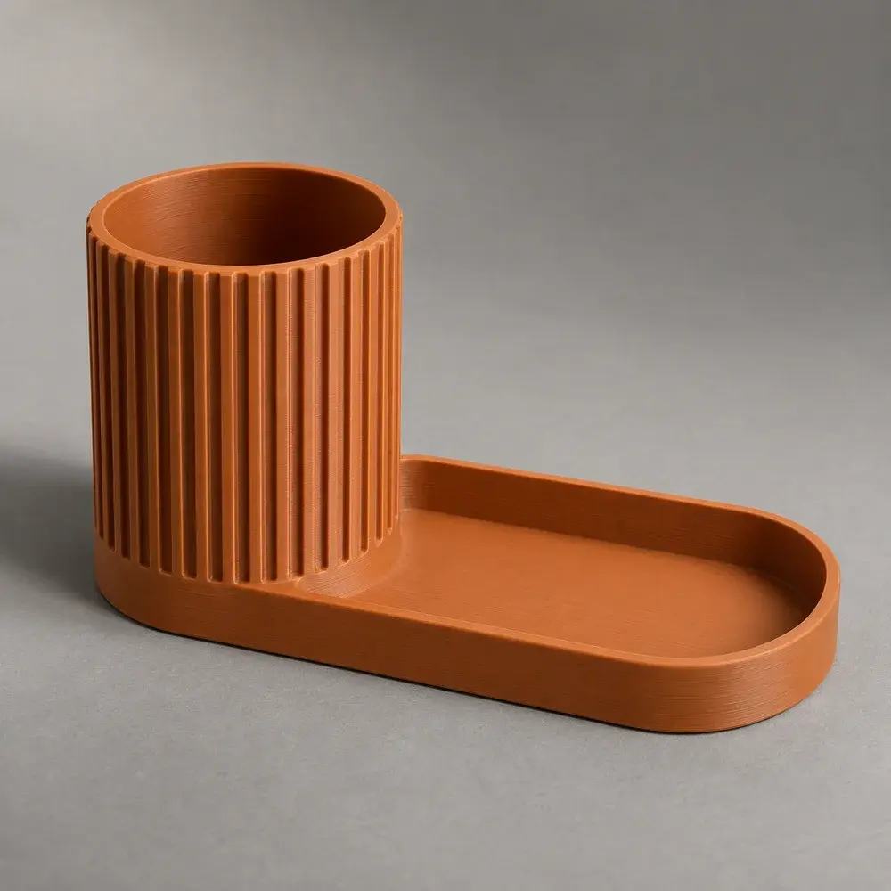 Orange 3D-printet penneholder med en lille bakke